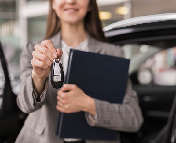 female hands holding folder car keys
